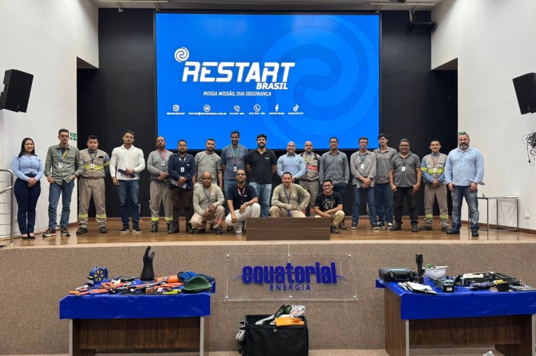 Pessoas reunidas em auditório da Equatorial Energia com tela azul ao fundo.